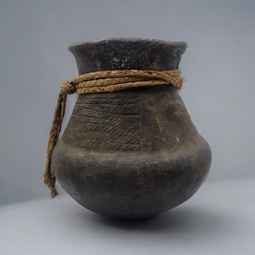 469 - A SOUTH AMERICAN BLACKWARE POTTERY VASE
Bulbous form with incised decoration and rope twist collar.
... 