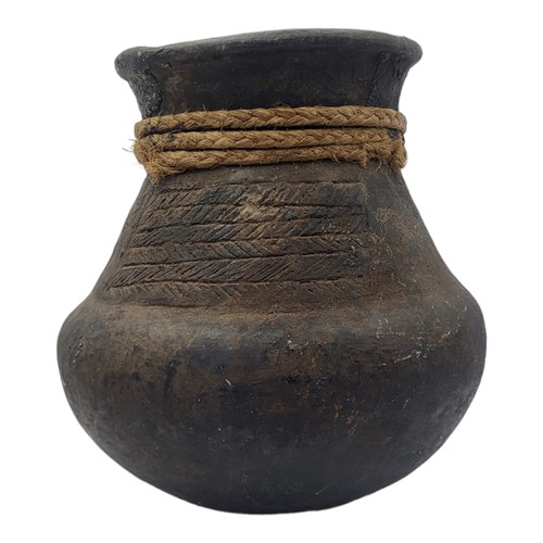 469 - A SOUTH AMERICAN BLACKWARE POTTERY VASE
Bulbous form with incised decoration and rope twist collar.
... 