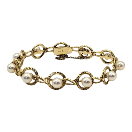 17 - MIKIMOTO, A VINTAGE 14CT GOLD AND PEAL BRACELET
Having a single row of pearls within a pierced desig... 