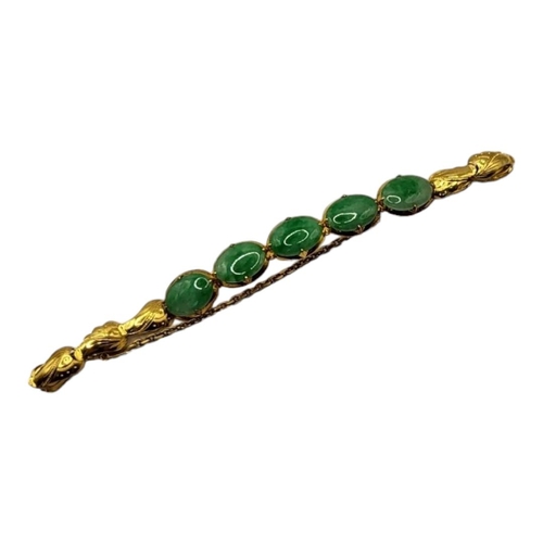 19 - A VINTAGE CHINESE YELLOW METAL AND JADE BRACELET
Five cabochon cut stones with scrolled yellow metal... 