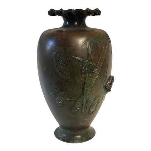 192 - A JAPANESE MEIJI PERIOD HEAVY BRONZE VASE
Decorated in relief with a tiger stalking through a bamboo... 