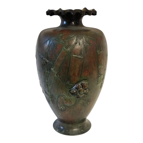 192 - A JAPANESE MEIJI PERIOD HEAVY BRONZE VASE
Decorated in relief with a tiger stalking through a bamboo... 