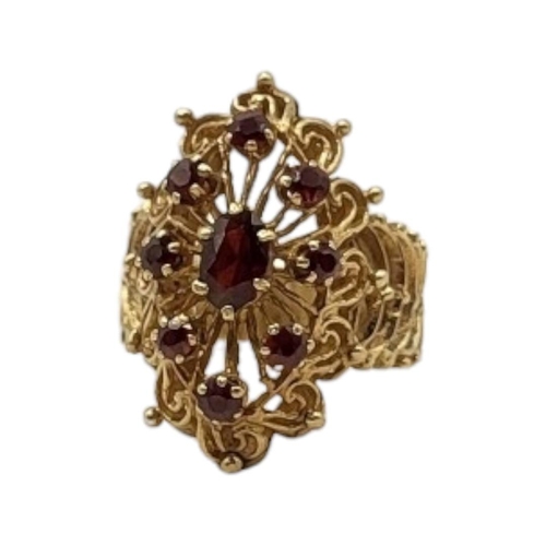 45 - A VINTAGE YELLOW METAL AND GARNET CLUSTER RING
Having an oval cut central stone edged with round cut... 