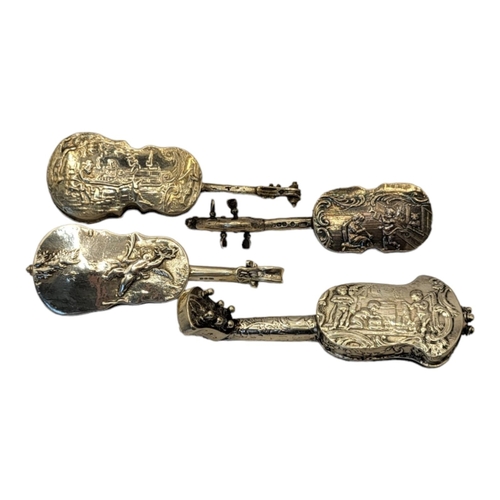 26 - A COLLECTION OF FOUR EARLY 20TH CENTURY SILVER NOVELTY CELLO
Having embossed figural decoration, unm... 