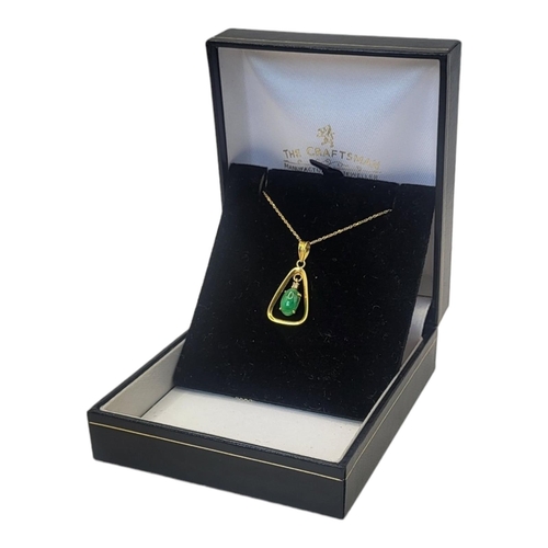 51 - A VINTAGE 14CT GOLD AND JADE PENDANT NECKLACE
An oval cut stone in a triangular mount, on a fine lin... 