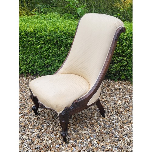 515 - A VICTORIAN ROSEWOOD LOW CHAIR
Having cream upholstery with scrolled back and carved cabriole legs o... 