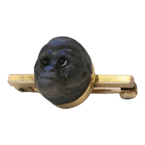 52 - A 19TH CENTURY YELLOW METAL AND LABRADORITE 'MONKEY' BROOCH
A carved head with glass set eyes on a p... 