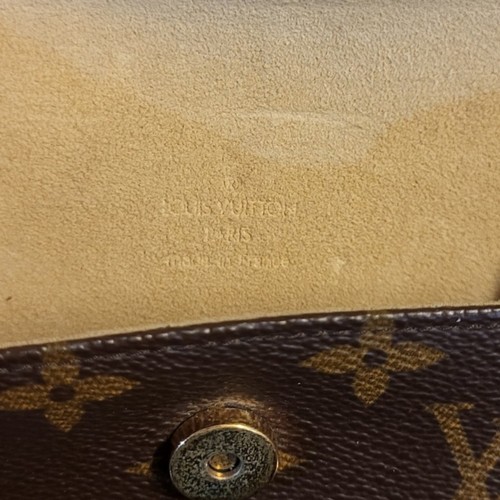 214 - LOUIS VUITTON, A VINTAGE BROWN LEATHER CLUTCH PURSE
Having a single handle and  LV monogram, in a LV... 