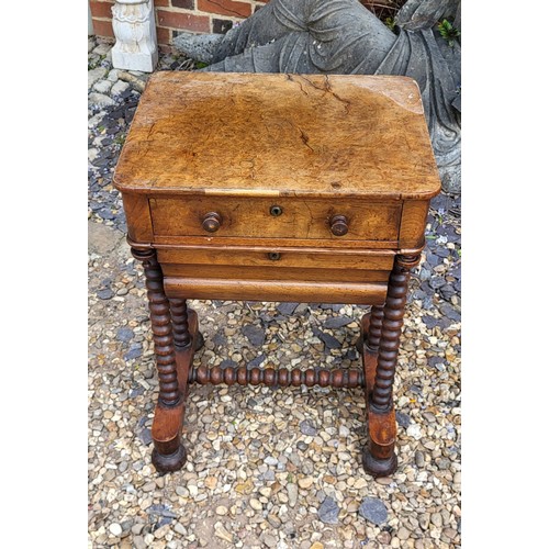 508 - A 19TH CENTURY BURR WALNUT SEWING TABLE
The compartmental drawer above a lined storage box, on bobbi... 