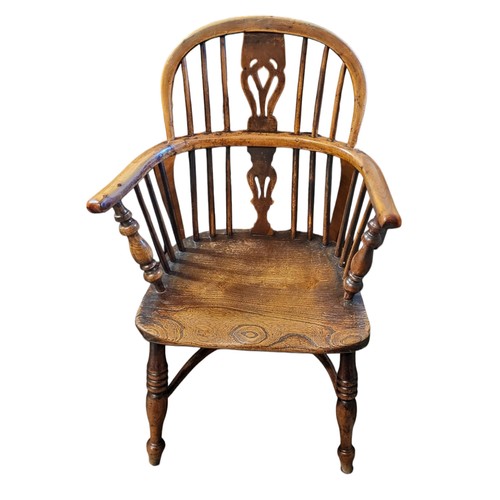 521 - A 19TH CENTURY YEW AND ELM WINDSOR CHAIR
Pierced splat, solid saddle seat, on turned legs with crino... 