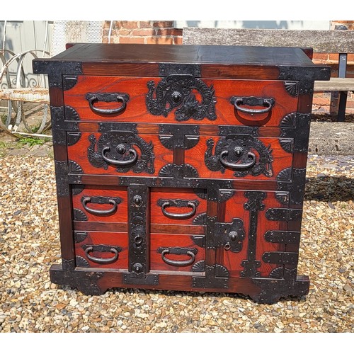 524 - A JAPANESE ELM SIDE CABINET 
With an arrangement of drawers and cupboards with heavy iron fittings i... 