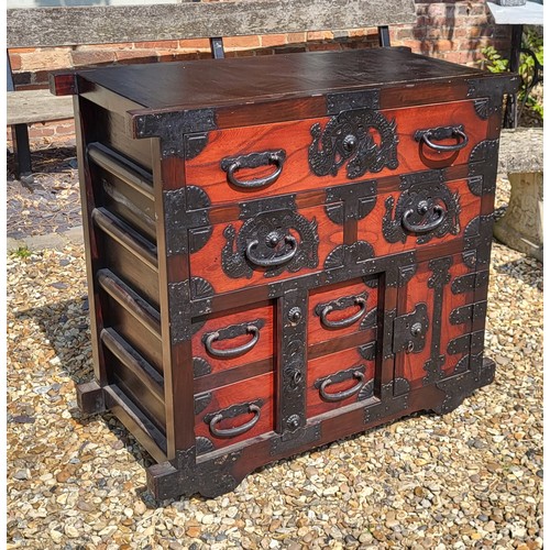 524 - A JAPANESE ELM SIDE CABINET 
With an arrangement of drawers and cupboards with heavy iron fittings i... 