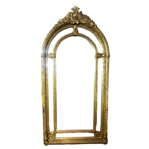 575 - A LARGE 19TH CENTURY STYLE GILT FRAMED MIRROR
Arched form crested with a floral cartouche above sect... 