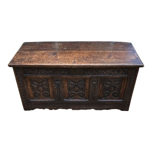 550 - AN 18TH CENTURY OAK COFFER
With three carved panelled front.
(117cm x 52cm x 56cm)