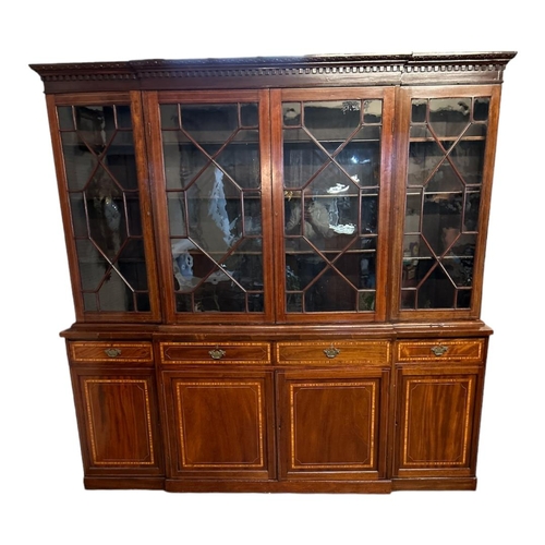 557 - A MID 20TH CENTURY SHERATON REVIVAL MAHOGANY AND SATINWOOD BANDED BREAKFRONT WING BOOKCASE
With four... 