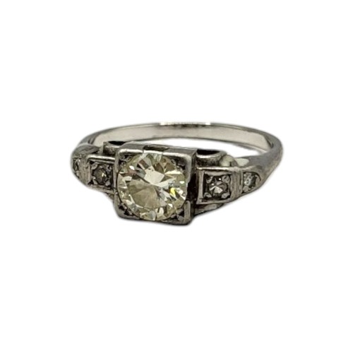 140 - AN EARLY 20TH CENTURY WHITE METAL AND DIAMOND RING
The central round cut diamond in a square form st... 