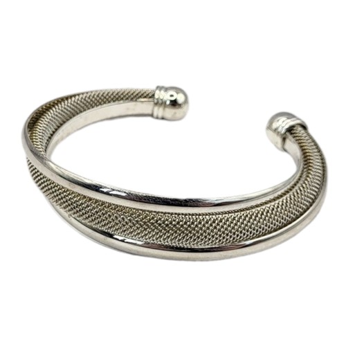 148 - TIFFANY, A VINTAGE SILVER 'TWISTED MESH CUFF' BANGLE
Marked ‘Tiffany and Co.’, in a green fabric pou... 