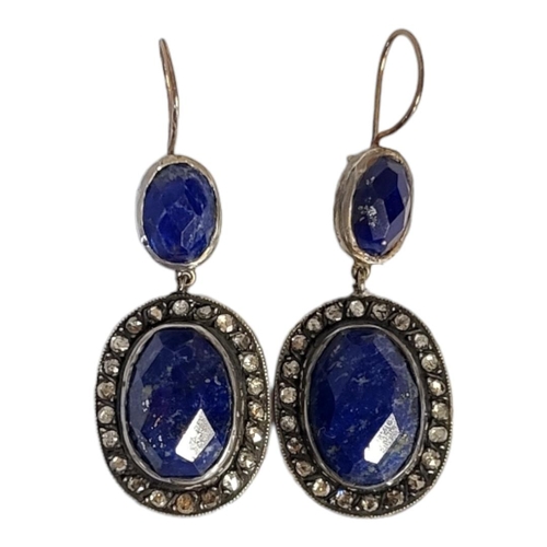 43 - A PAIR OF WHITE METAL DIAMOND AND LAPIS LAZULI EARRINGS 
Having a cabochon cut lapis stone edged wit... 