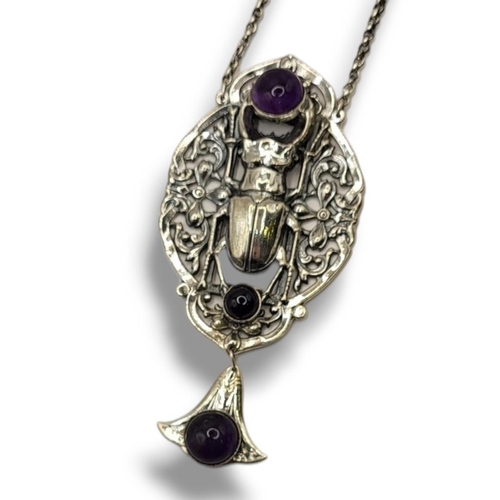 48 - AN ART NOUVEAU STYLE STERLING SILVER SCARAB BEETLE NECKLACE
Set with cabochon cut amethyst stones in... 