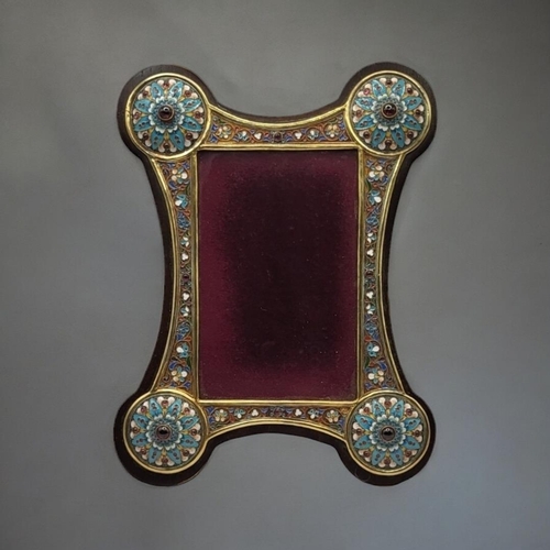 54 - A RUSSIAN STYLE ENAMEL AND GILT METAL WORK PICTURE FRAME
Borders having floral decoration and caboch... 