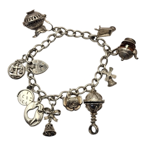 61 - A VINTAGE SILVER CHARM BRACELET
Ten various charms including teapot and rose.
(approx 18cm)

Conditi... 