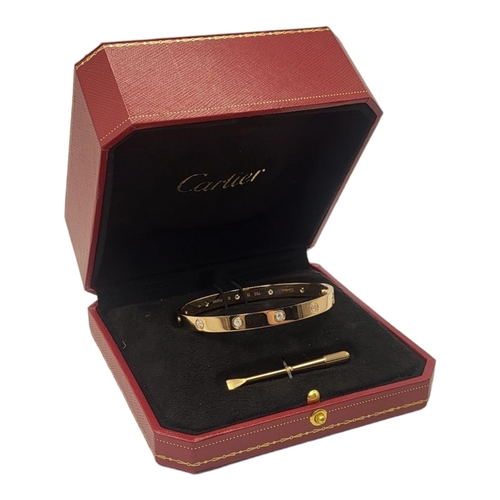 35A - CARTIER, AN 18CT GOLD AND DIAMOND LOVE BANGLE
Set with ten round cut diamonds and screw fasteners, m... 