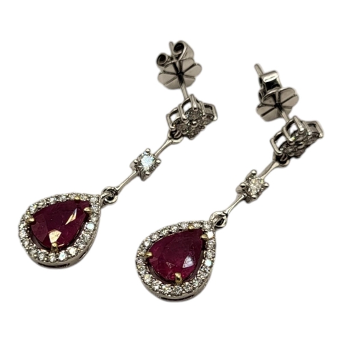 14A - A PAIR OF WHITE METAL, RUBY AND DIAMOND EARRINGS
Each set with a single pear cut ruby edged with dia... 