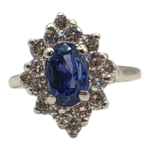 28A - AN 18CT WHITE GOLD, SAPPHIRE AND DIAMOND CLUSTER RING
The oval cut central sapphire ,edged with roun... 