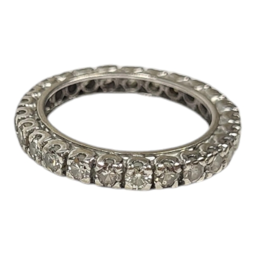 12 - A VINTAGE WHITE METAL AND DIAMOND FULL ETERNITY RING
Having a row of round cut diamonds in a plain d... 