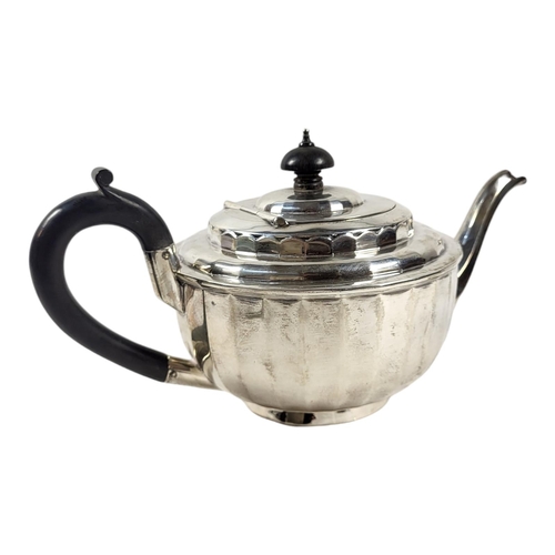 180 - A 20TH CENTURY SILVER TEAPOT
Having carved ebonised wooden finial and handle and flutes to body, hal... 