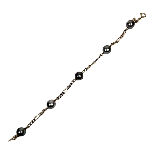 25 - A YELLOW METAL AND CULTURED PEARL BRACELET
Set with five grey/black tone cultured pearls on Figaro l... 