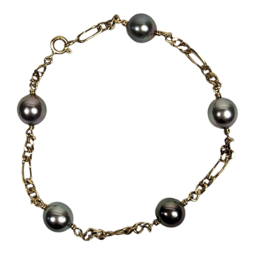 25 - A YELLOW METAL AND CULTURED PEARL BRACELET
Set with five grey/black tone cultured pearls on Figaro l... 