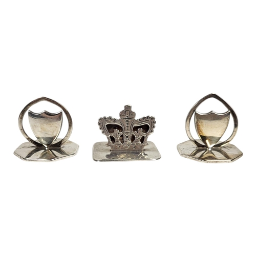 43 - A COLLECTION OF THREE EARLY 20TH CENTURY SILVER MENU HOLDERS
Two of shield form and one coronet, to ... 