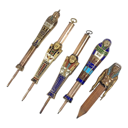 51 - A COLLECTION OF FOUR EARLY 20TH CENTURY YELLOW METAL AND ENAMEL ‘EGYPTIAN REVIVAL’ PROPELLING PENCIL... 