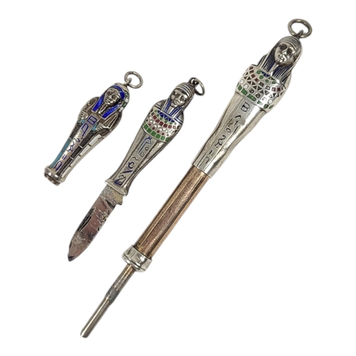 53 - TWO EARLY 20TH CENTURY WHITE METAL AND ENAMEL EGYPTIAN REVIVAL PROPELLING PENCILS
Together with a pe... 