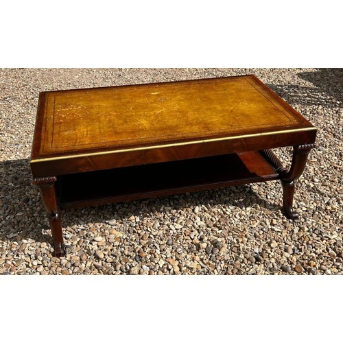 581 - A REGENCY STYLE FLAME MAHOGANY COFFEE TABLE
With gilt tooled surface, on double U supports with scro... 