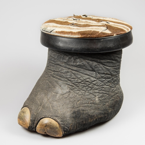 319 - AN EARLY 20TH CENTURY TAXIDERMY AFRICAN ELEPHANT FOOT STOOL (LOXODONTA AFRICANA).
With later upholst... 