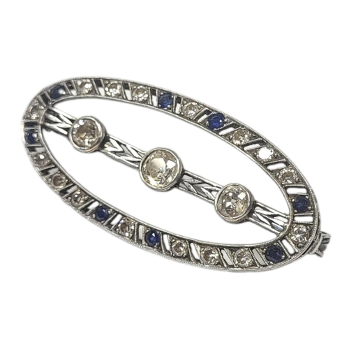 566 - AN ART DECO WHITE METAL, DIAMOND AND SAPPHIRE OVAL BROOCH
Edged with sapphire and diamonds with thre... 