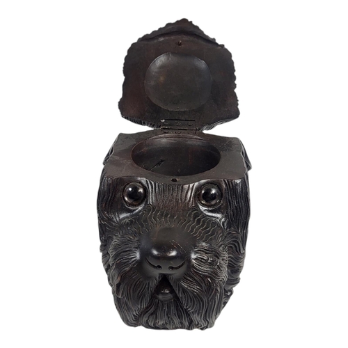 710 - A 20TH CENTURY BLACK FOREST CARVED WOODEN DOG TOBACCO JAR
Having a hinged lid with internal compartm... 