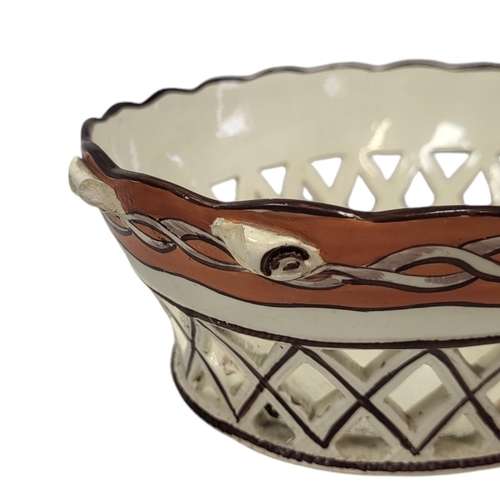 711 - DAVENPORT, AN EARLY 19TH CENTURY OVAL POTTERY BASKET
Pierced form with painted decoration, together ... 