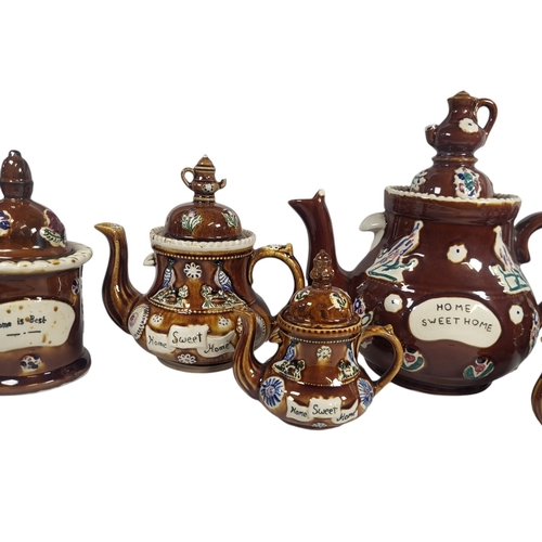 729 - A COLLECTION OF FIVE 20TH CENTURY POTTERY BARGE WARE TEAPOTS
Each having a miniature teapot finial a... 