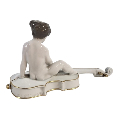 771A - FERDINAND LIBERMANN, 1883 - 1941, FOR ROSENTHAL, A PORCELAIN MODEL OF A CHERUB BOY SEATED ON A CELLO... 