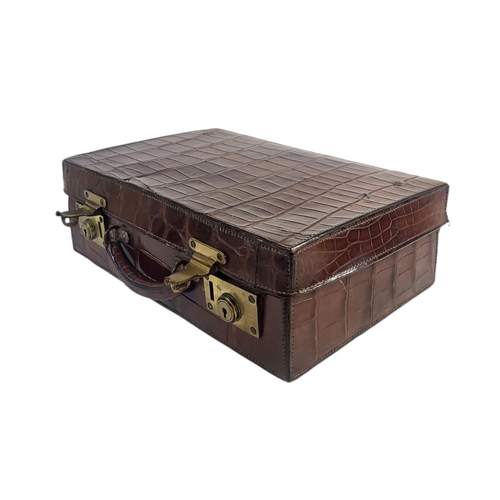 784 - AN EARLY 20TH CENTURY CROCODILE SKIN ATTACHE CASE
Having a single carry handle, fitted interior and ... 