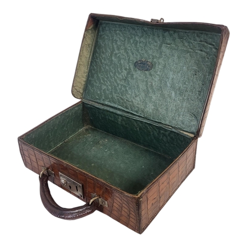 785 - AN EARLY 20TH CENTURY CROCODILE SKIN ATTACHE CASE
Having a single carry handle, bearing label North ... 