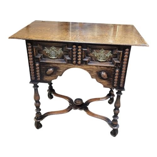 984 - AN 18TH CENTURY STYLE OAK LOWBOY 
Two drawers fitted with brass handles, above a shaped apron, on tu... 