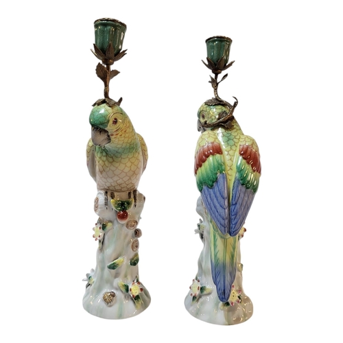 101 - A PAIR OF CONTINENTAL PORCELAIN AND BRASS ‘PARROT’ CANDLESTICKS
Standing pose with colourful decorat... 