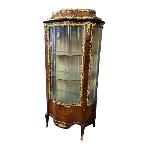 448 - A 19TH CENTURY FRENCH MAHOGANY AND GILT BRONZE MOUNTED VITRINE
The two serpentine glazed doors enclo... 