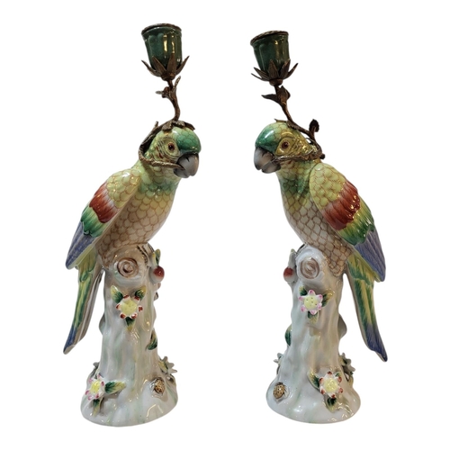 101 - A PAIR OF CONTINENTAL PORCELAIN AND BRASS ‘PARROT’ CANDLESTICKS
Standing pose with colourful decorat... 