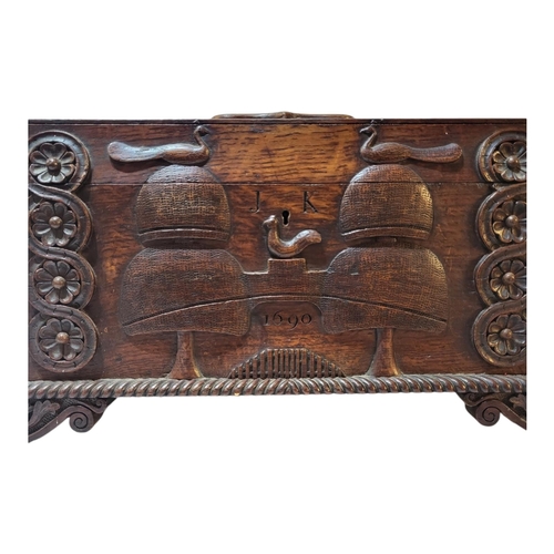 104 - AN EARLY 19TH CENTURY CARVED OAK TEA CADDY
Sarcophagus form with foliate shield to lid, twin handles... 