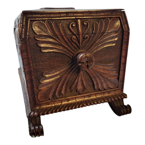 104 - AN EARLY 19TH CENTURY CARVED OAK TEA CADDY
Sarcophagus form with foliate shield to lid, twin handles... 